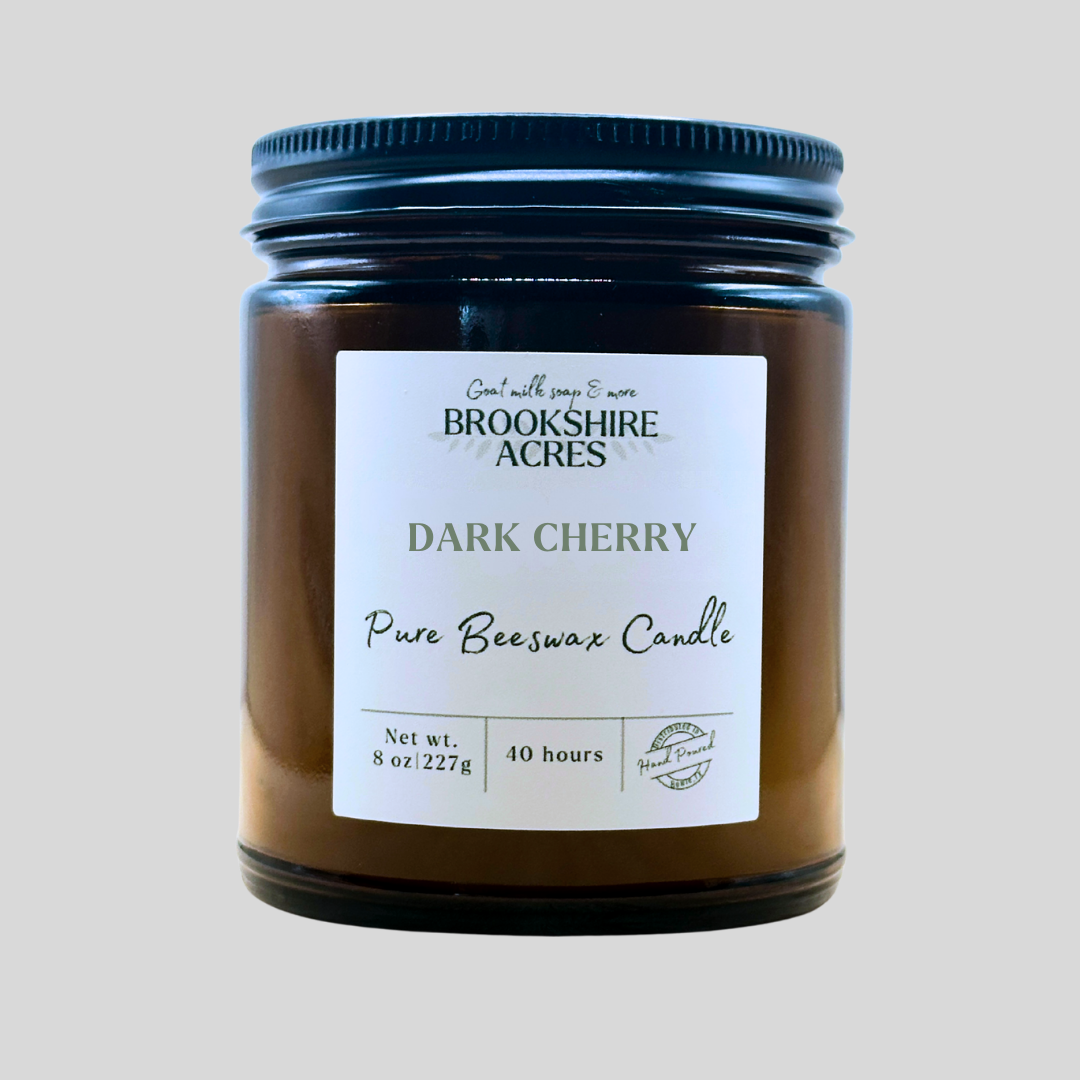 Brookshire Acres Dark Cherry pure beeswax candle in a glass jar with a black lid on a light gray background