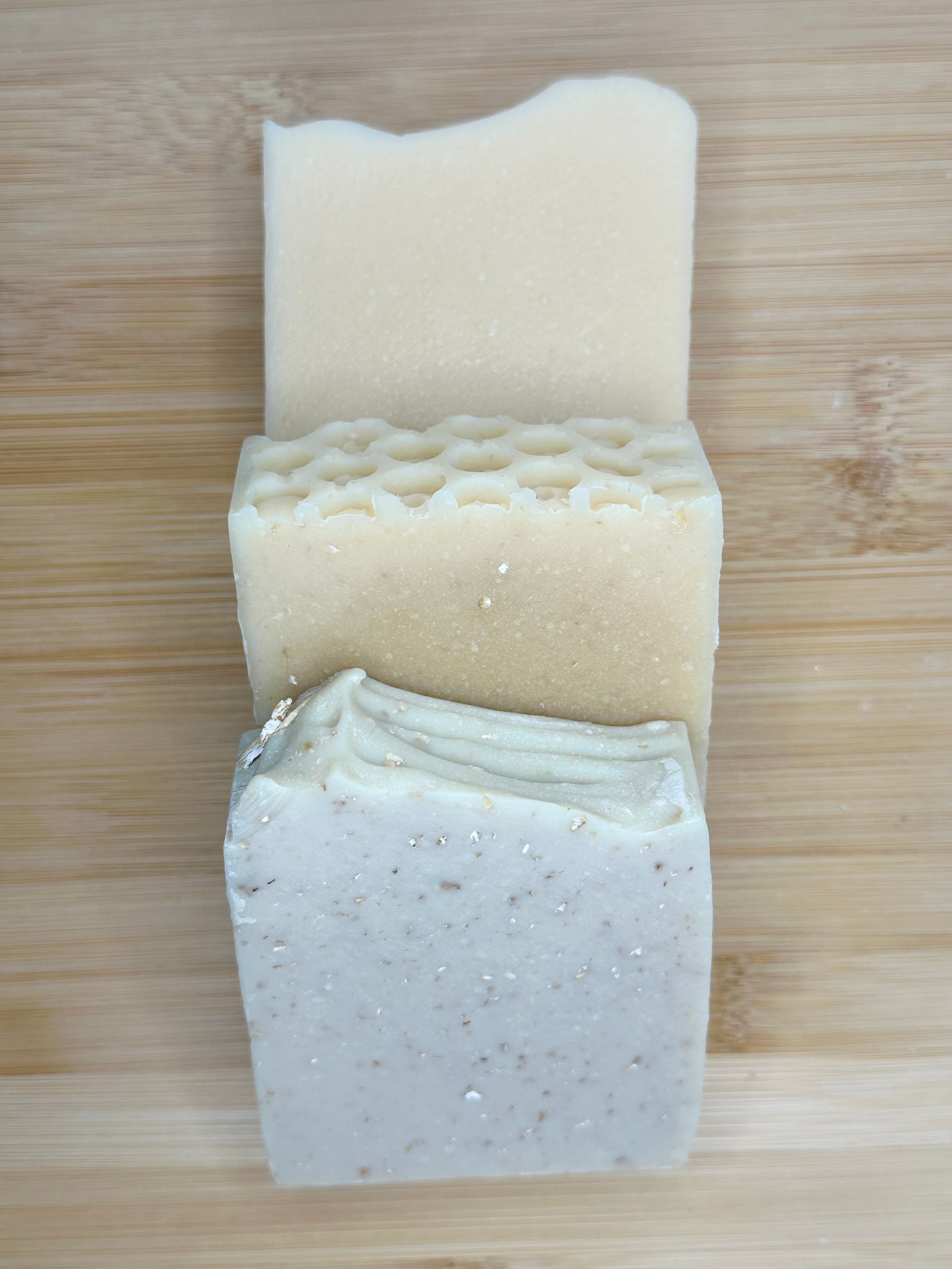 3 soaps stacked together on a wood background