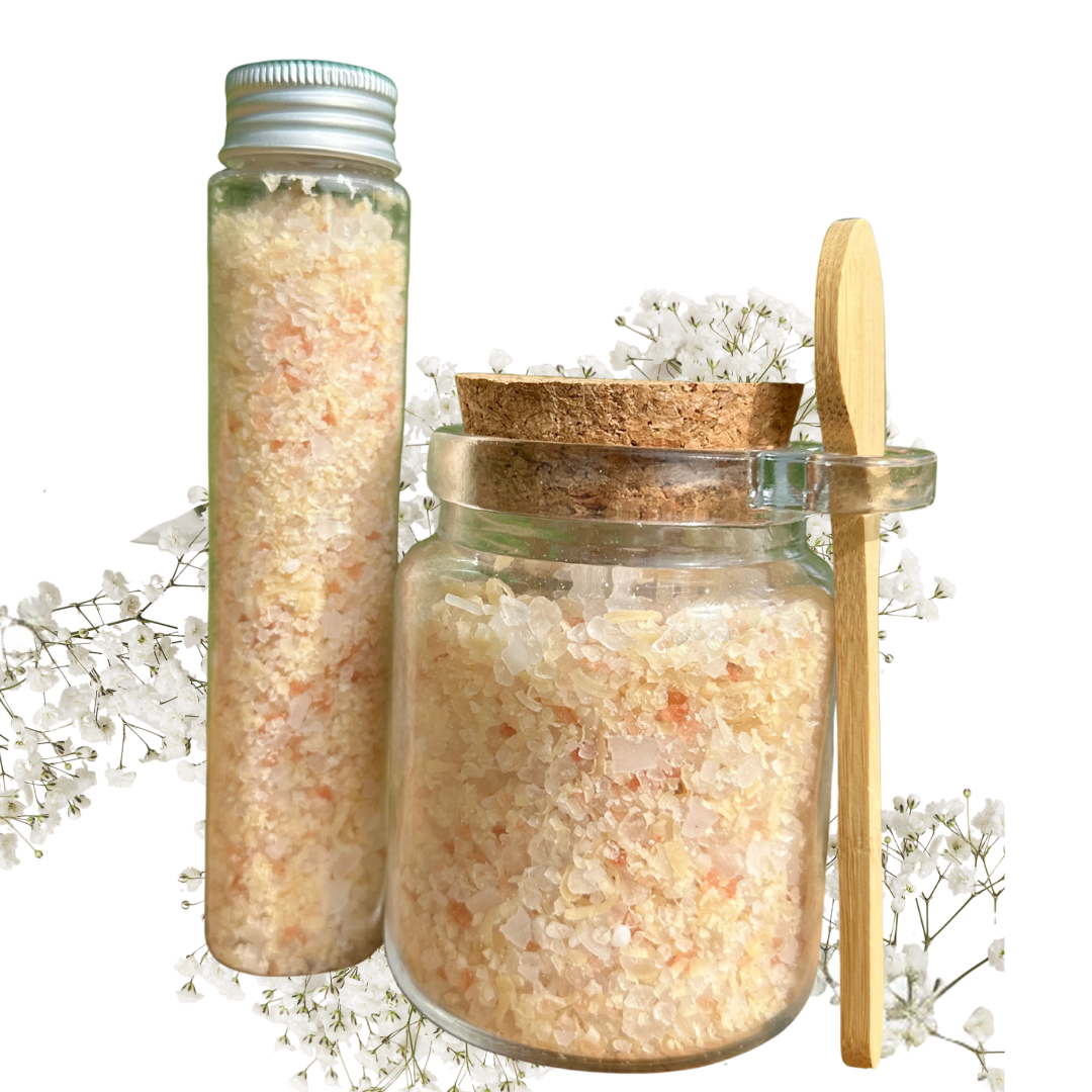 Glass jar with cork lid and a bottle filled with bath salts on a white background