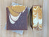 Two soap bars with brown, white, and gold color on a wooden surface