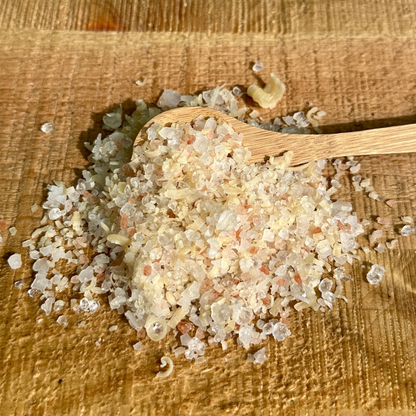 Wooden spoon with bath salt on a wooden surface